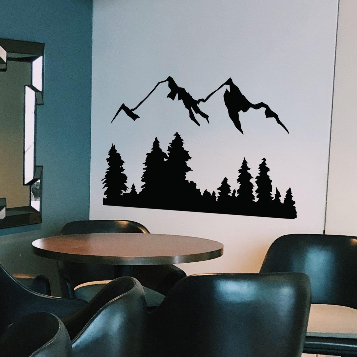 Black mountain decal on a white wall in a dining room.