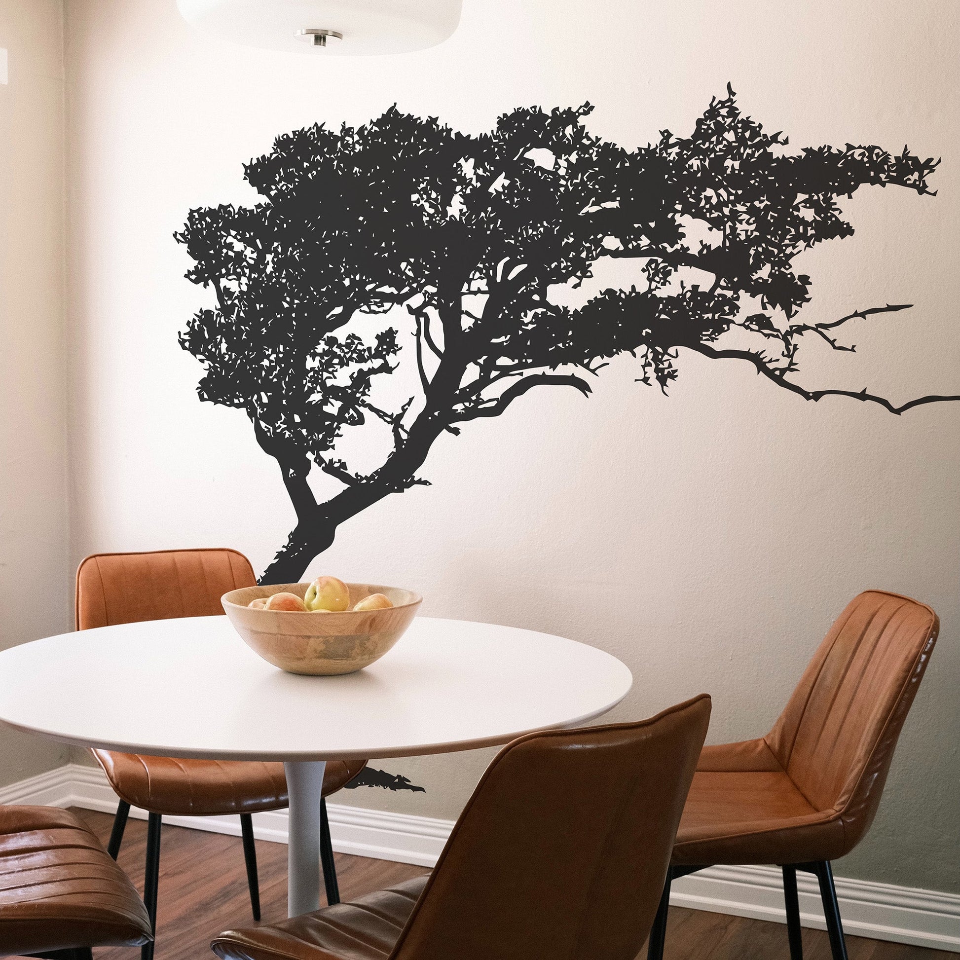 Black tree decal on a white wall in a dining room.
