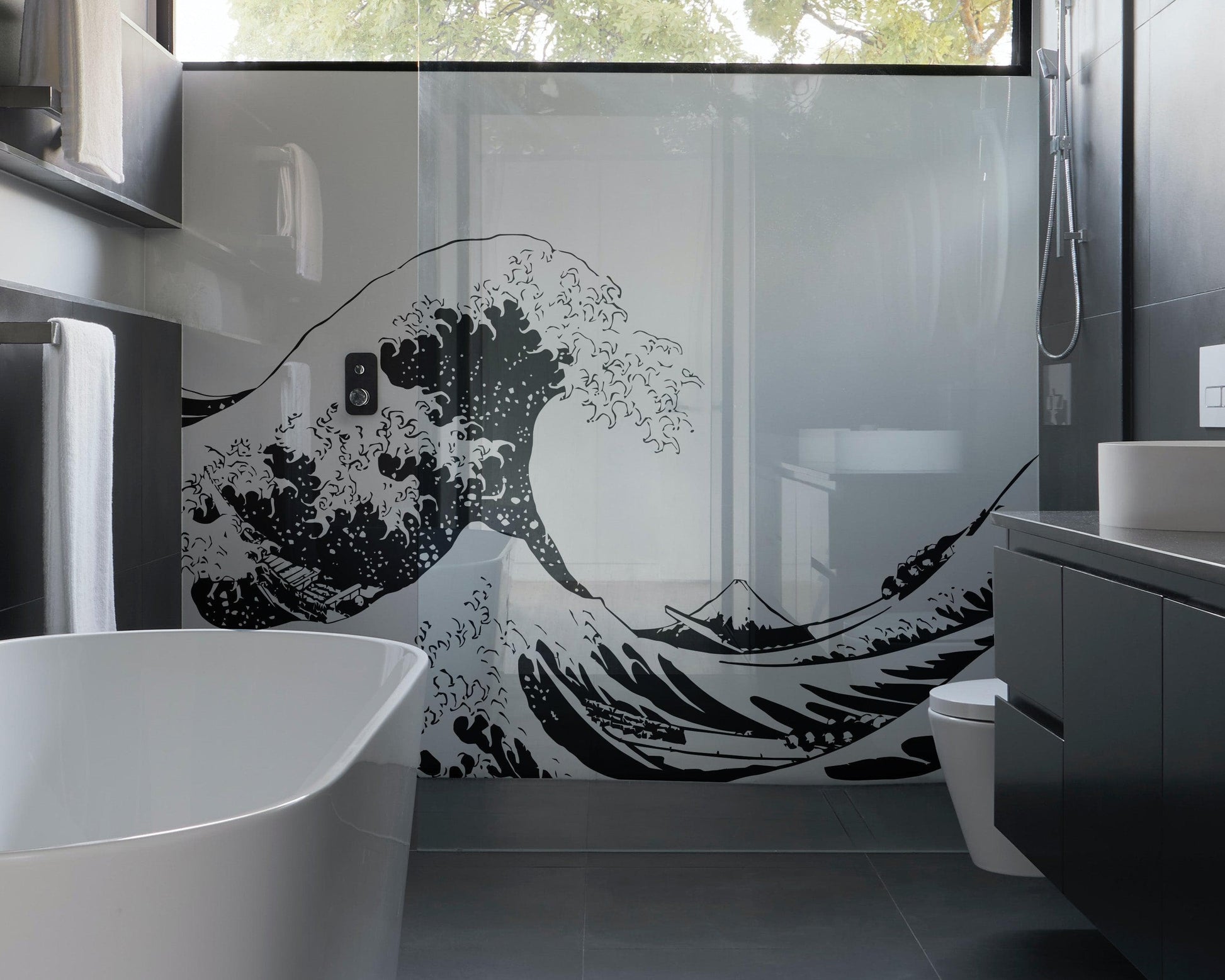 The Great Wave wall decal on a glass wall in a bathroom.