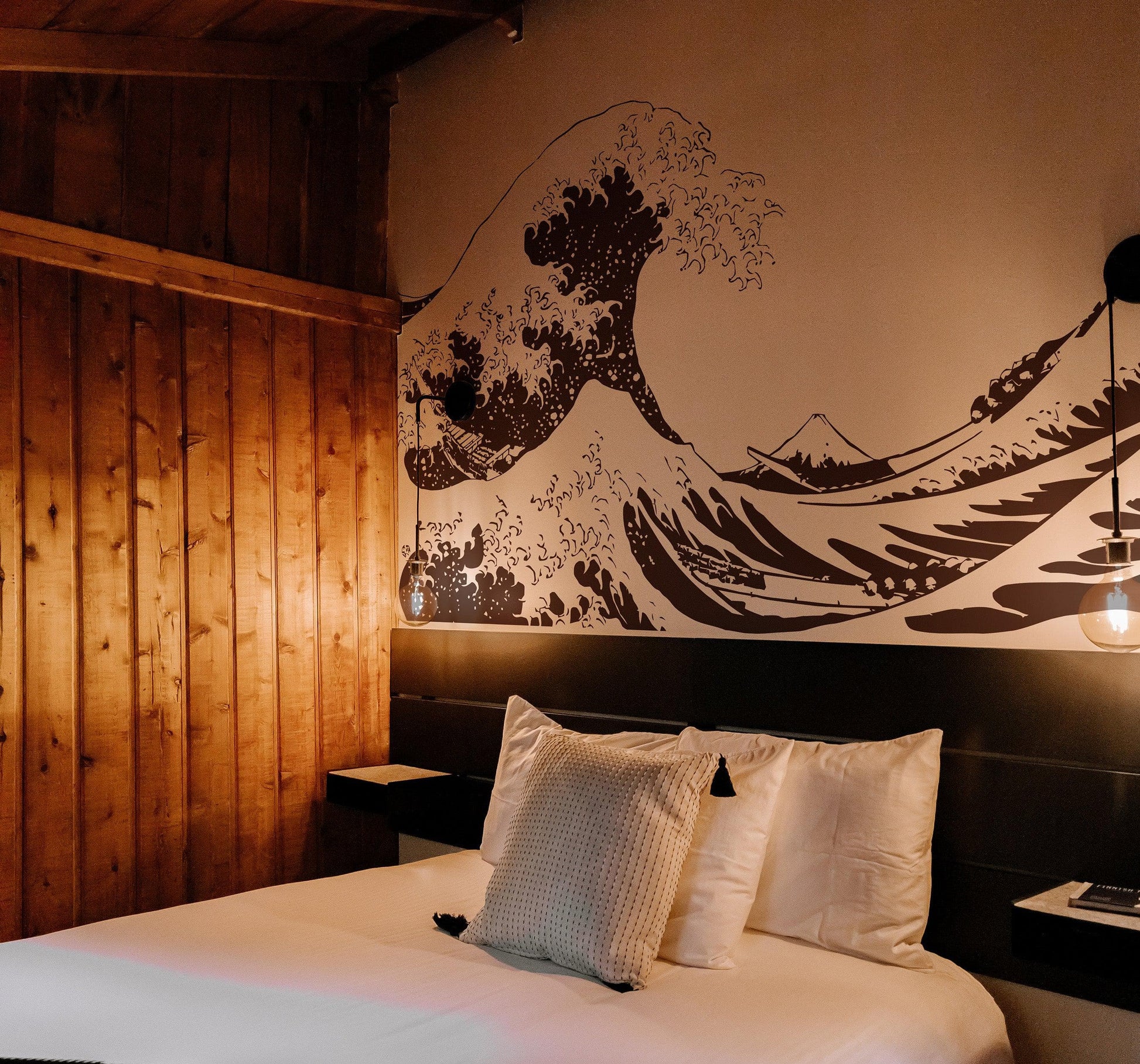 The Great Wave wall decal on a white wall in a bedroom.