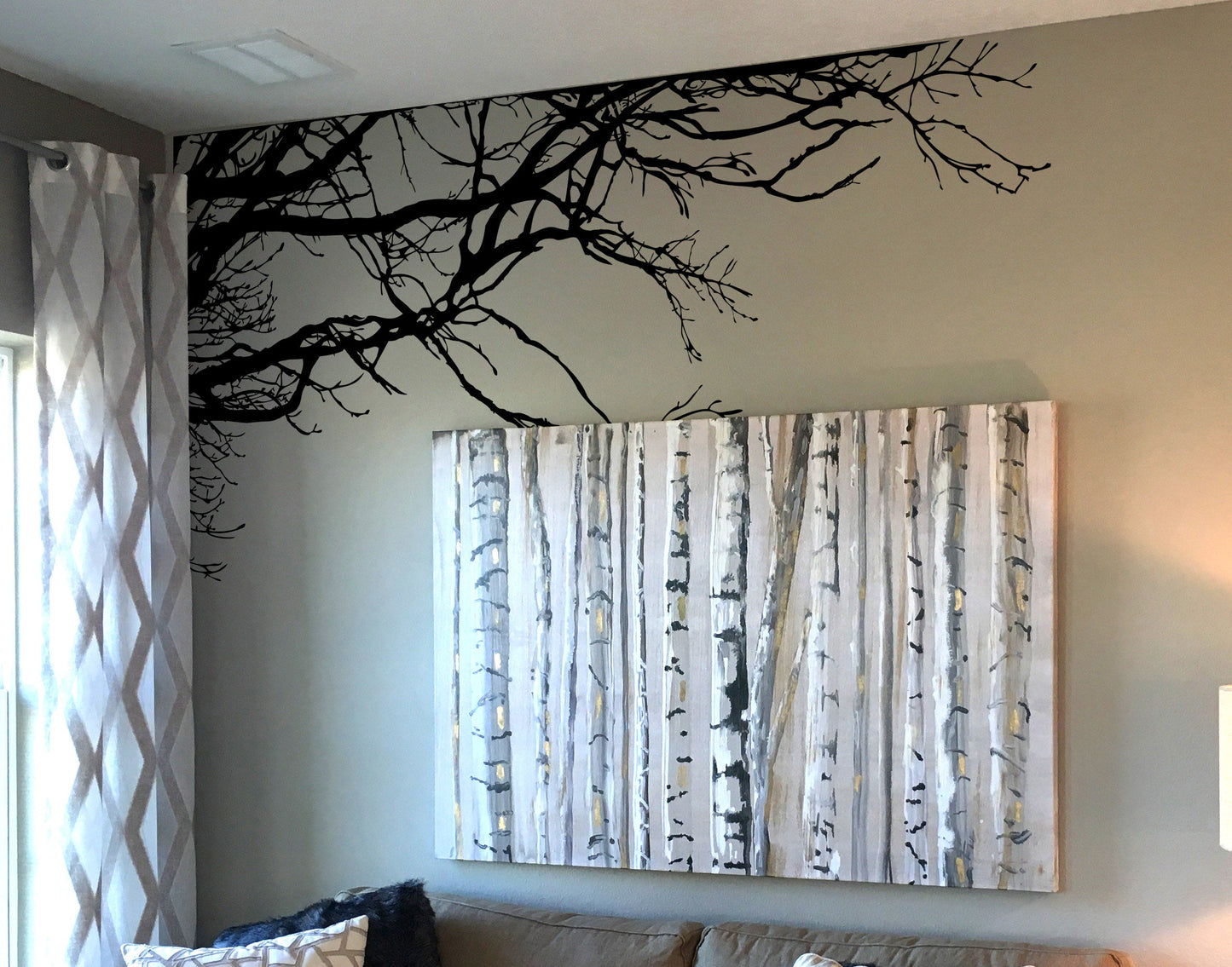 A cozy living room with a tree wall decal, adding a touch of nature to the space.