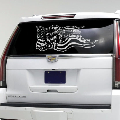 A white decal on a car window showing a soldier holding a gun and the American flag behind it. 