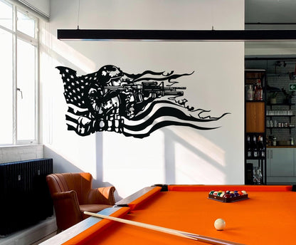 A black decal on a white wall showing a soldier holding a gun and the American flag behind it. Underneath it is an orange pool table and an armchair.