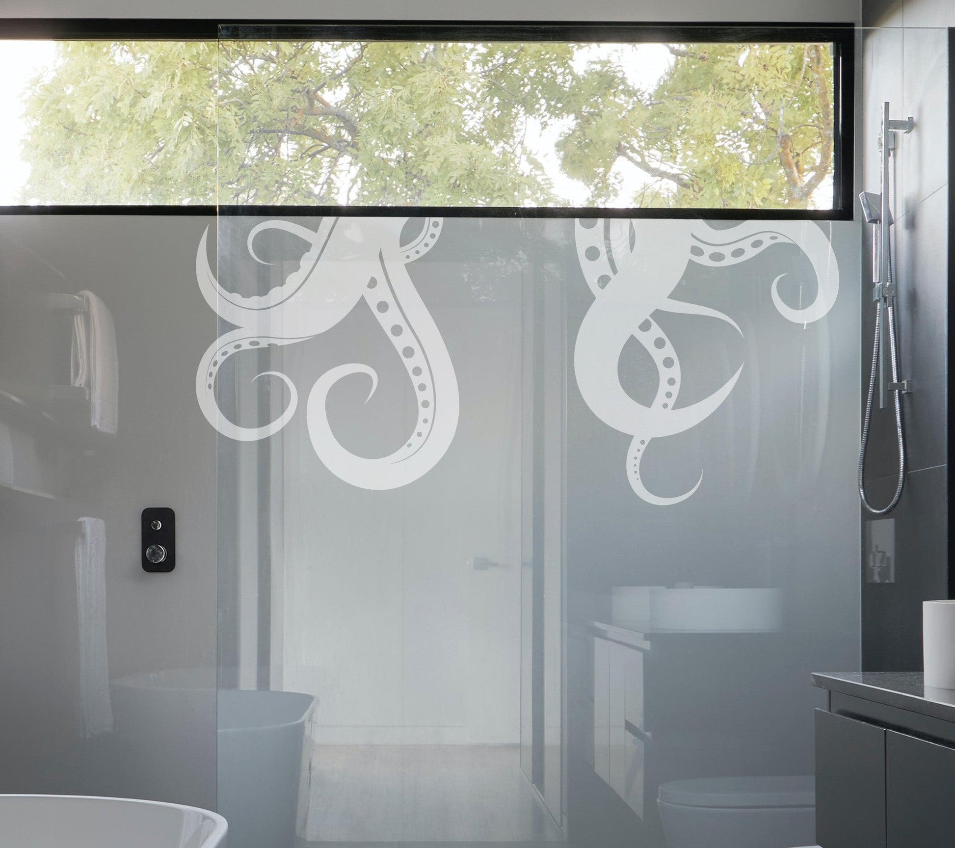 A white octopus tentacles wall decal on a bathroom glass door. 