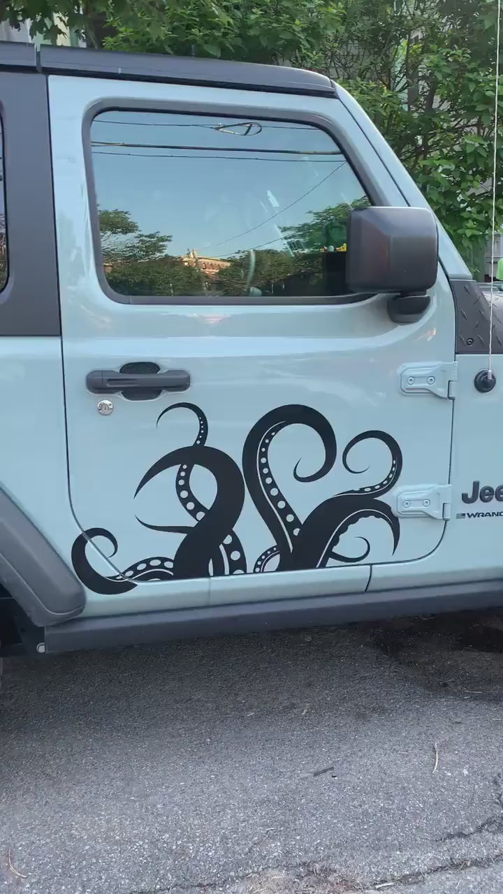 A video showing a black tentacles decal on a white truck door.