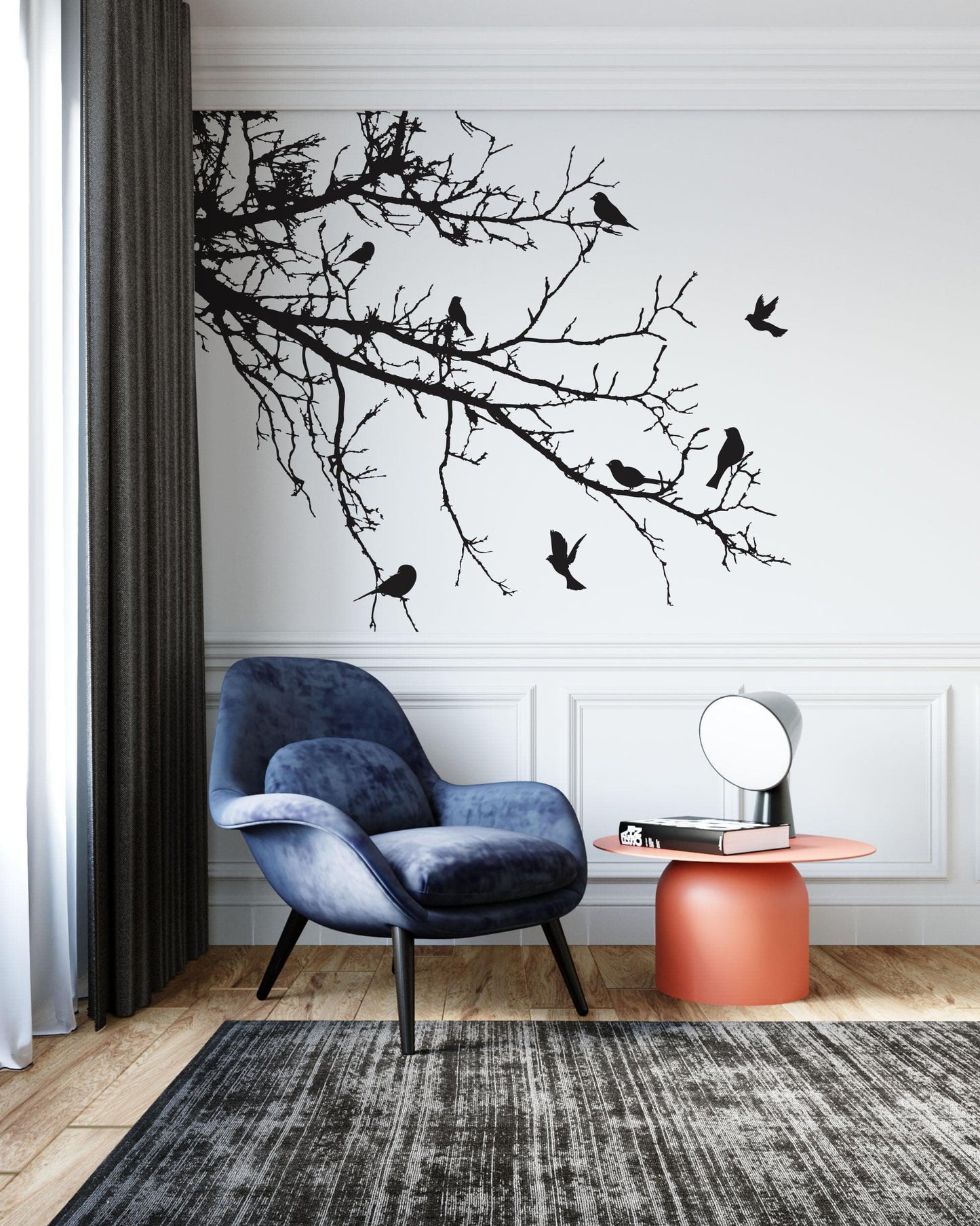 Black decal of 8 birds on tree branches on a white wall above a blue couch.