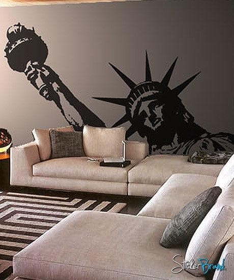A black decal of the Statue of Liberty on a gray wall in a living room.