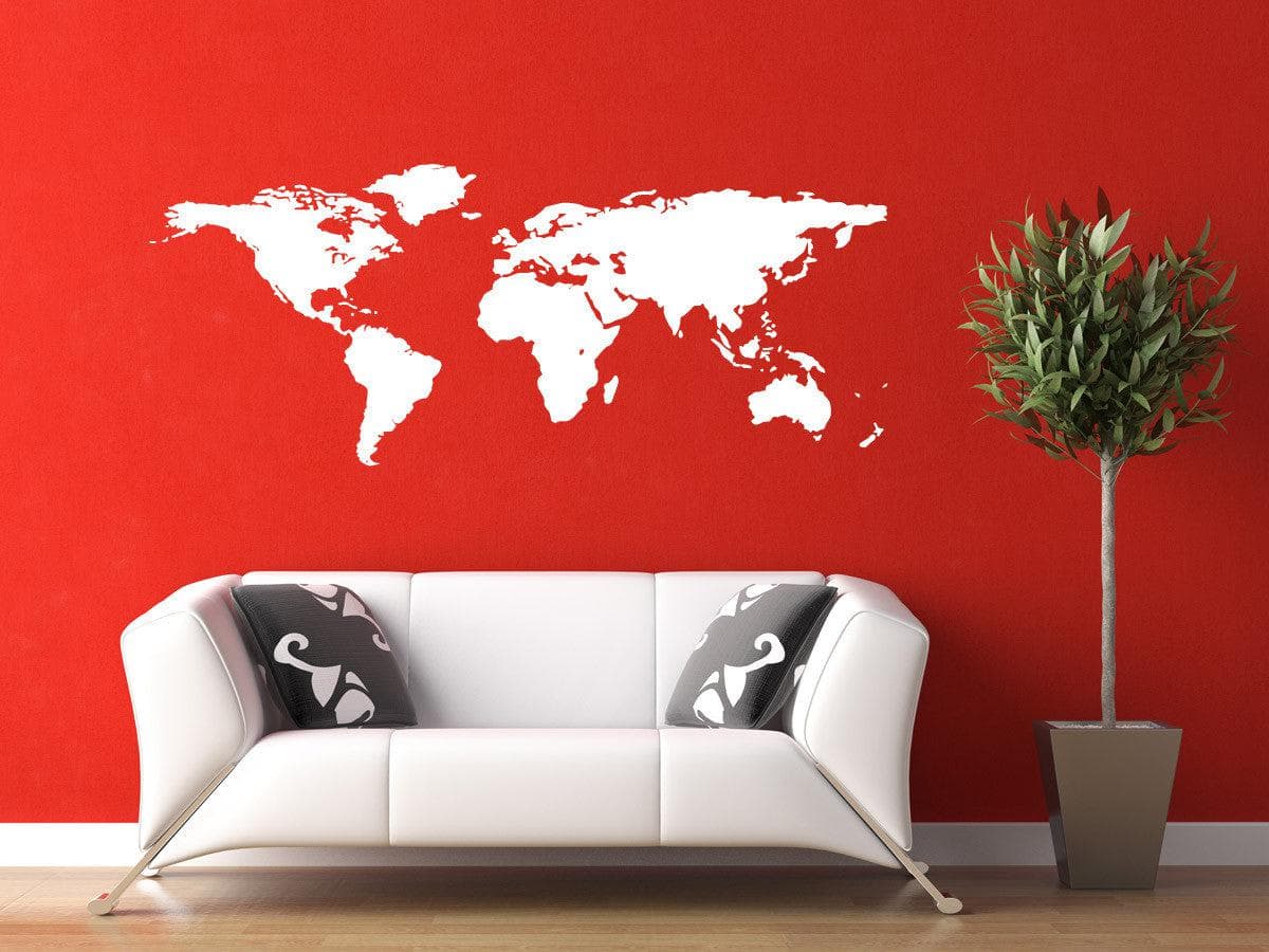 White world map decal on a red wall above a white couch.