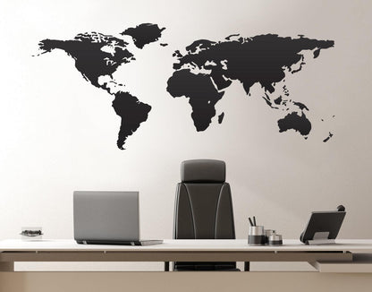 Gray world map decal on a white wall in an office.