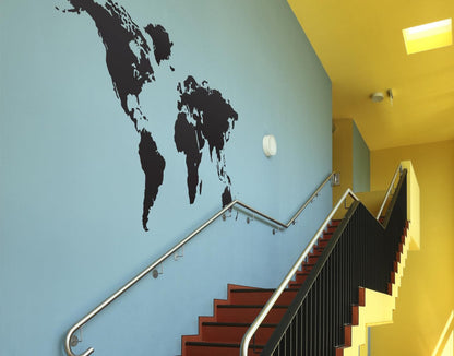 Black world map decal on a light blue wall above a staircase.