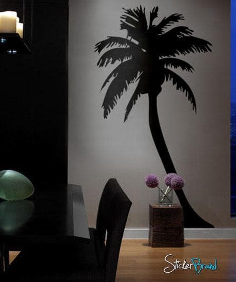 Black palm tree decals on a white wall near a dining room.