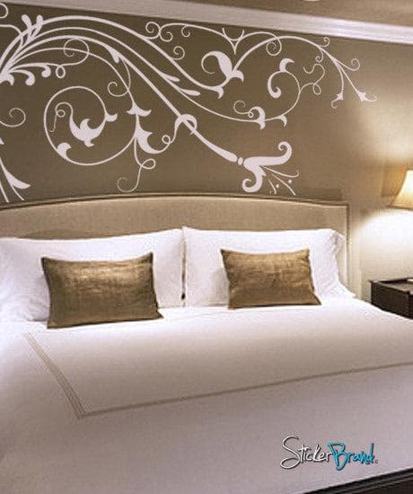 White floral vines with leaves on a gold wall in a bedroom.