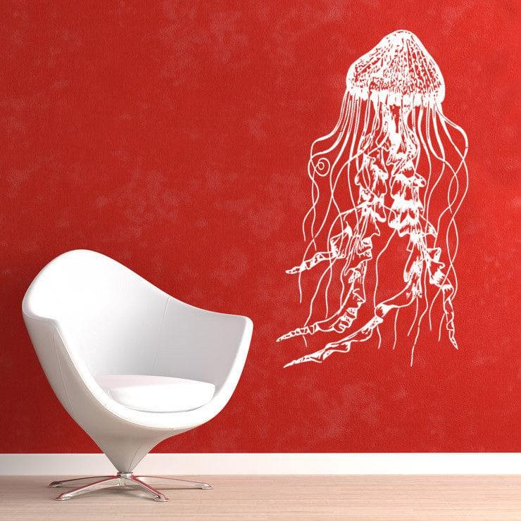 White jellyfish wall decal on a red wall near a white chair.