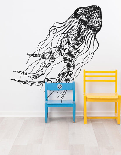 Black jellyfish decal on a white wall near blue and yellow chairs. 