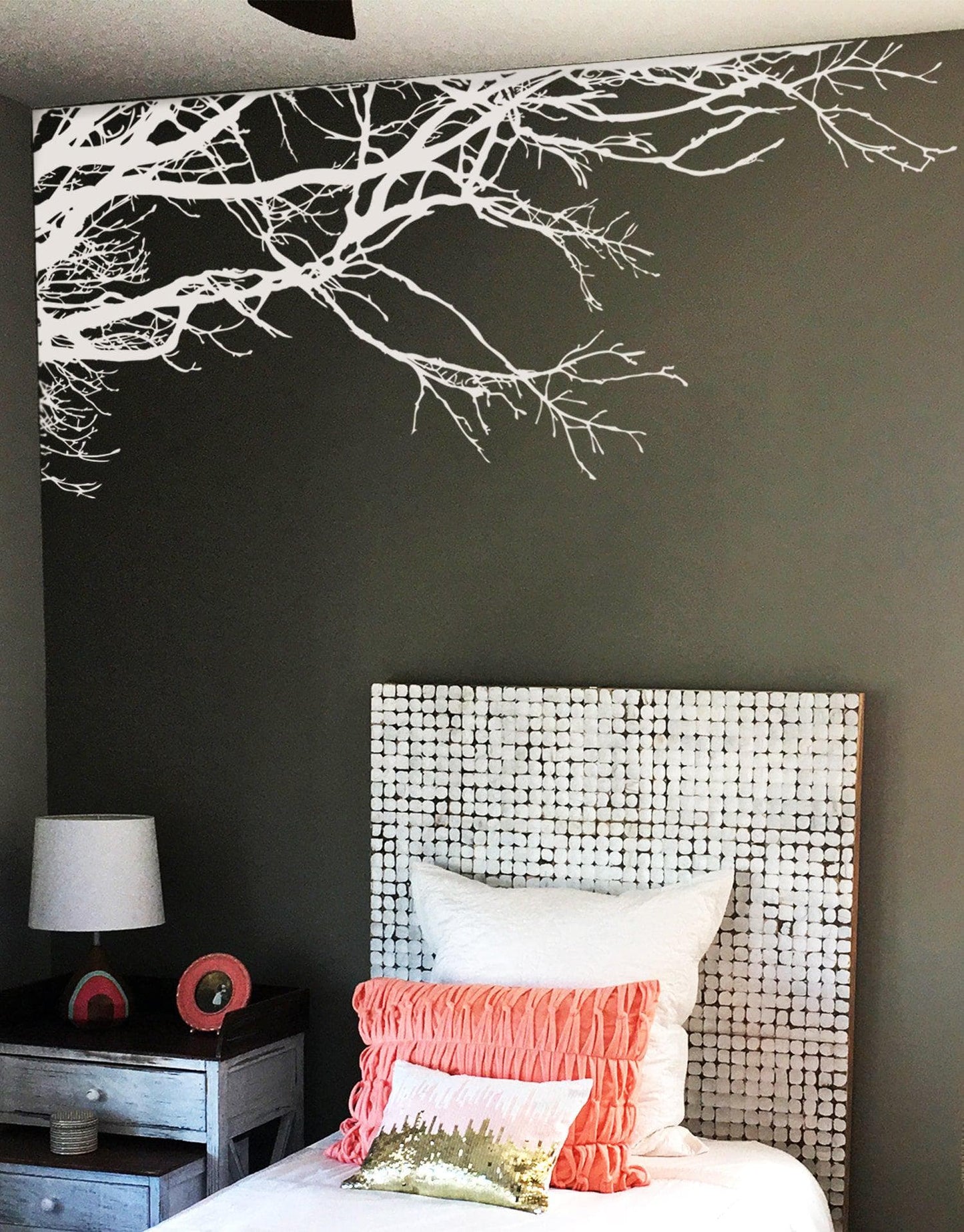 A dark wall with a white tree decal, adding a natural ambiance in the room. 