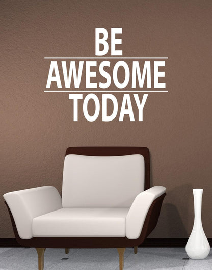 A white text decal saying "BE AWESOME TODAY" on a brown wall over a white chair.