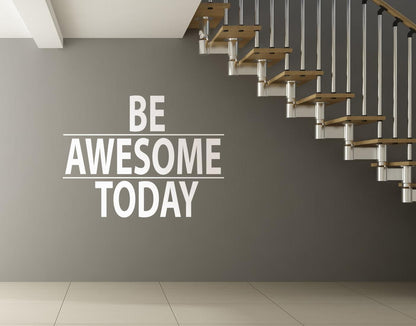 A white text decal saying "BE AWESOME TODAY" on a gray wall under a staircase.