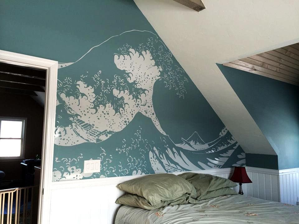 The Great Wave wall decal on a blue wall in a bedroom.