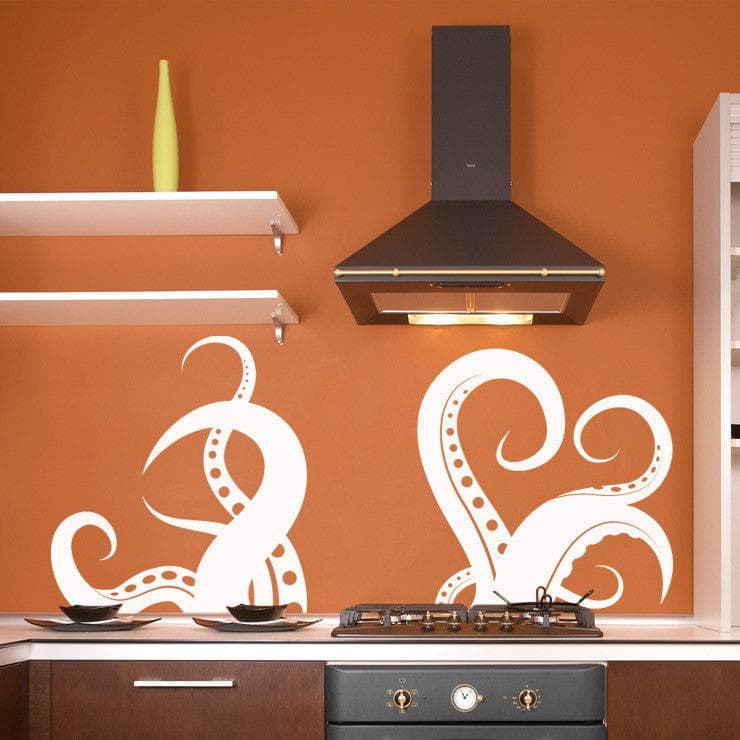 A white octopus tentacle decal on an orange wall in a kitchen.