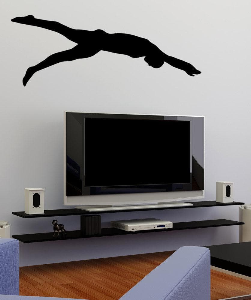 A black decal of a swimmer's silhouette on a white wall above a TV.