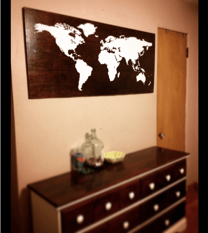 White world map decal on a wooden background in a living room.
