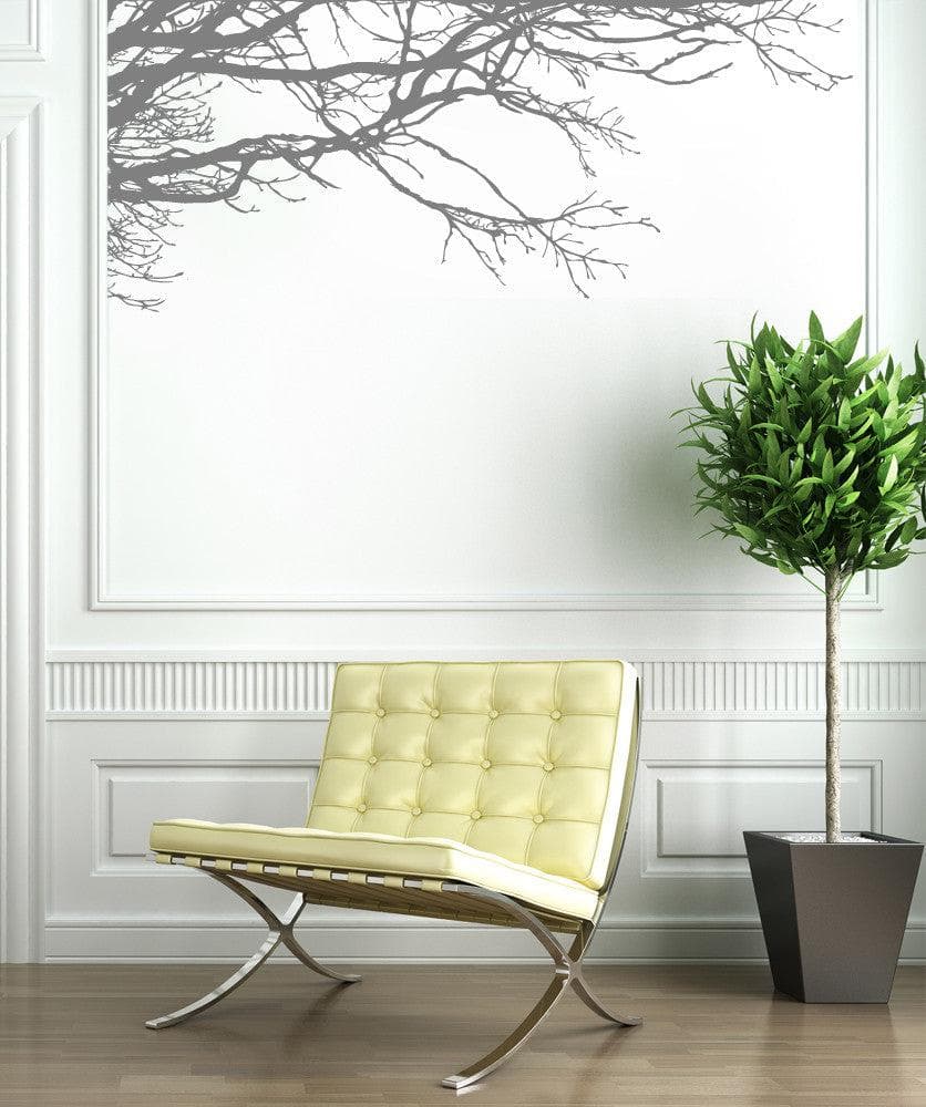 A white wall with a gray tree decal, adding a natural ambiance in the room. 
