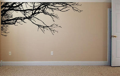 A light colored wall with a black tree decal, adding a natural ambiance in the room. 