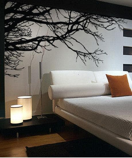 A white wall with a black tree decal, adding a natural ambiance in the room. 