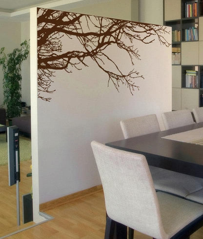 A white wall with a brown tree decal, adding a natural ambiance in the room. 