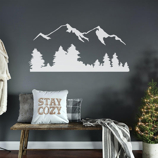 White mountain decal on a gray wallpaper above a bench and pillows. 