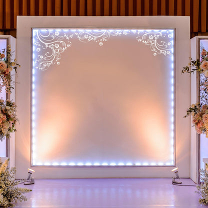 White swirling floral decals on a white wall on a stage.