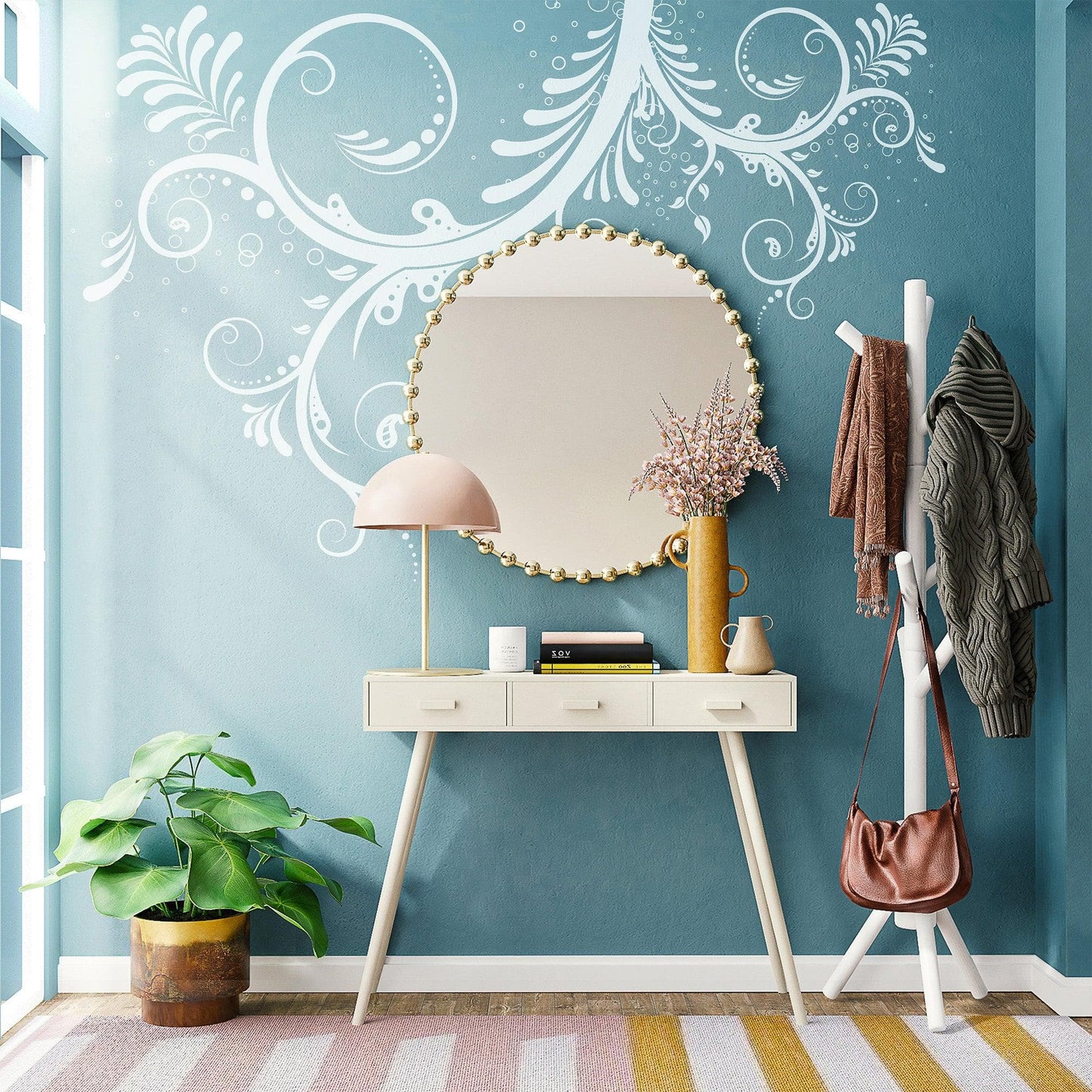 A white floral swirl decal on a blue wall above a mirror in a bedroom. 