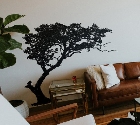 Black tree decal on a white wall in a living room.