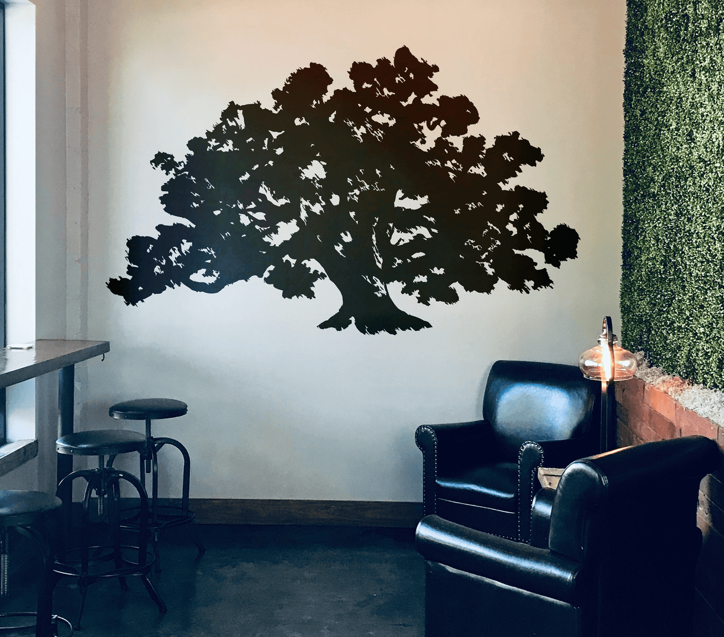 A black tree decal on a white wall in a cafe.