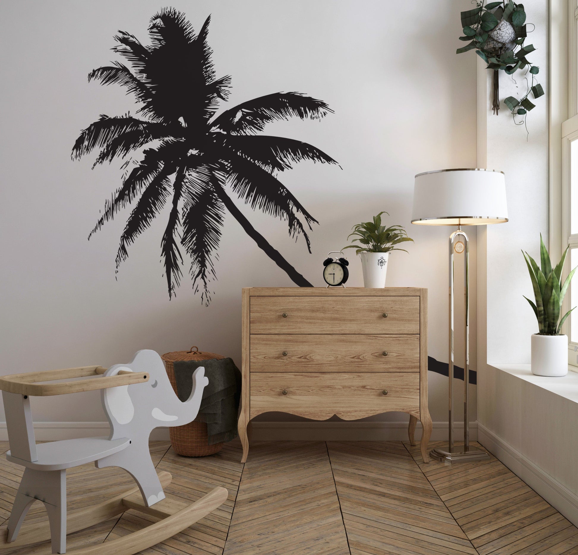 A black coconut tree decal on a white wall in a nursery.