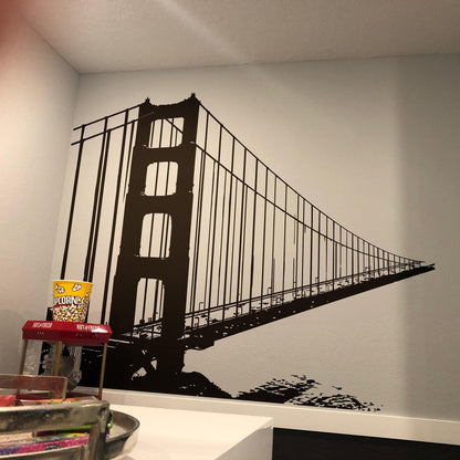 A black decal of the Golden Gate Bridge on a white wall.