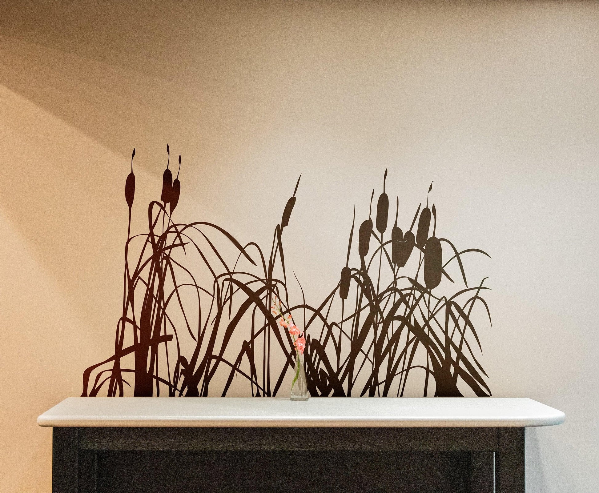 A black cattails decal on a white wall above a white marble counter.