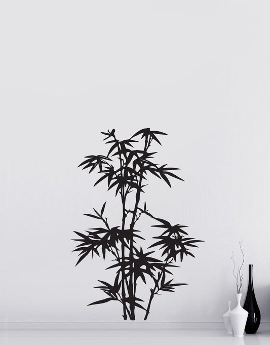 A black bamboo tree decal on a white wall near white and black vases.