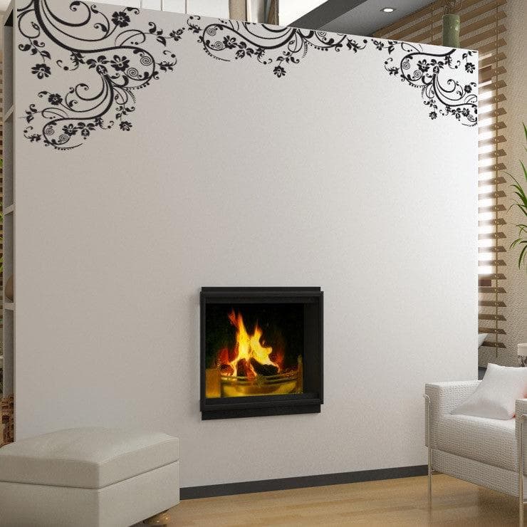 Black swirling floral decals on a white wall above a fireplace.