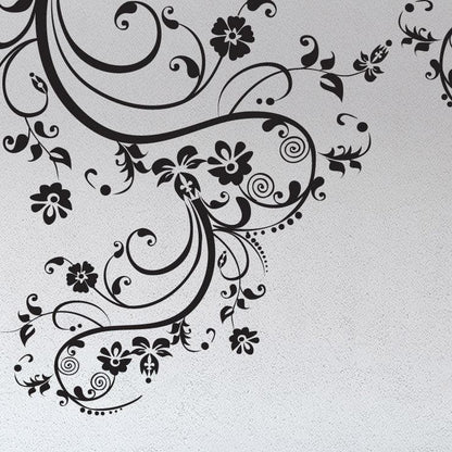 Black swirling floral decals on a white wall.