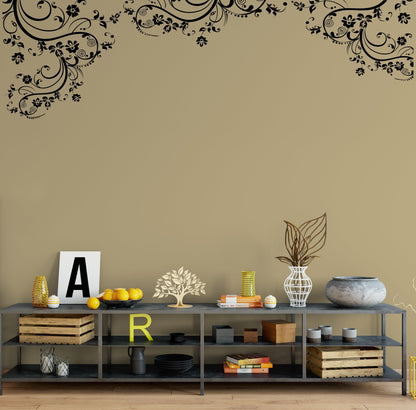 Black swirling floral decals on a light wall in a living room.
