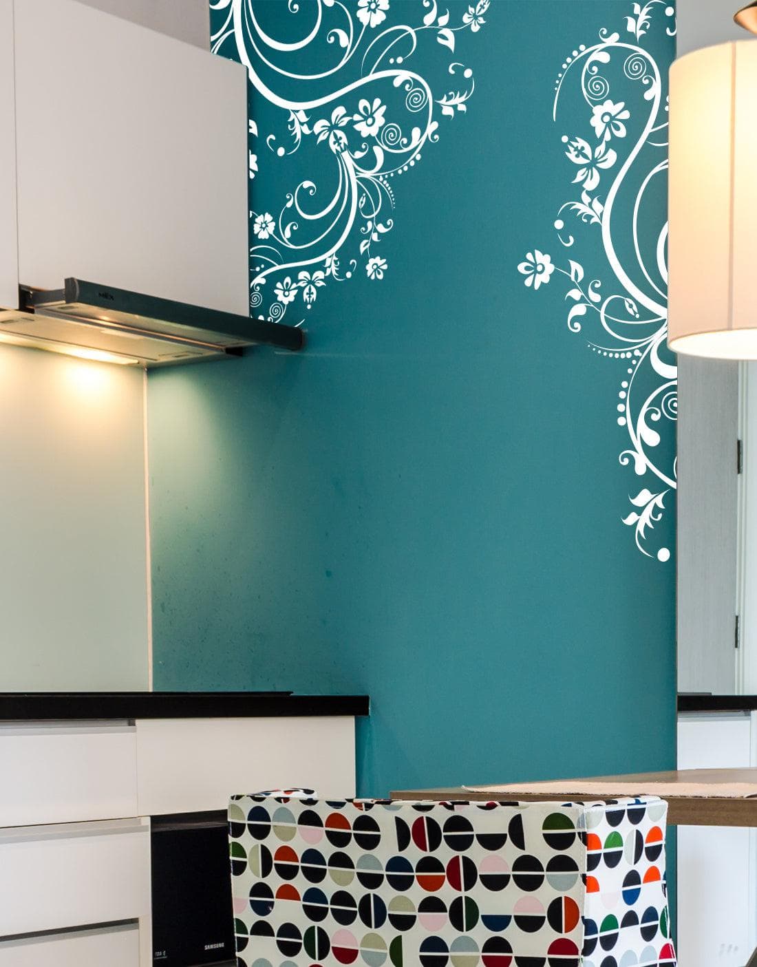 White swirling floral decals on a blue wall in a kitchen.