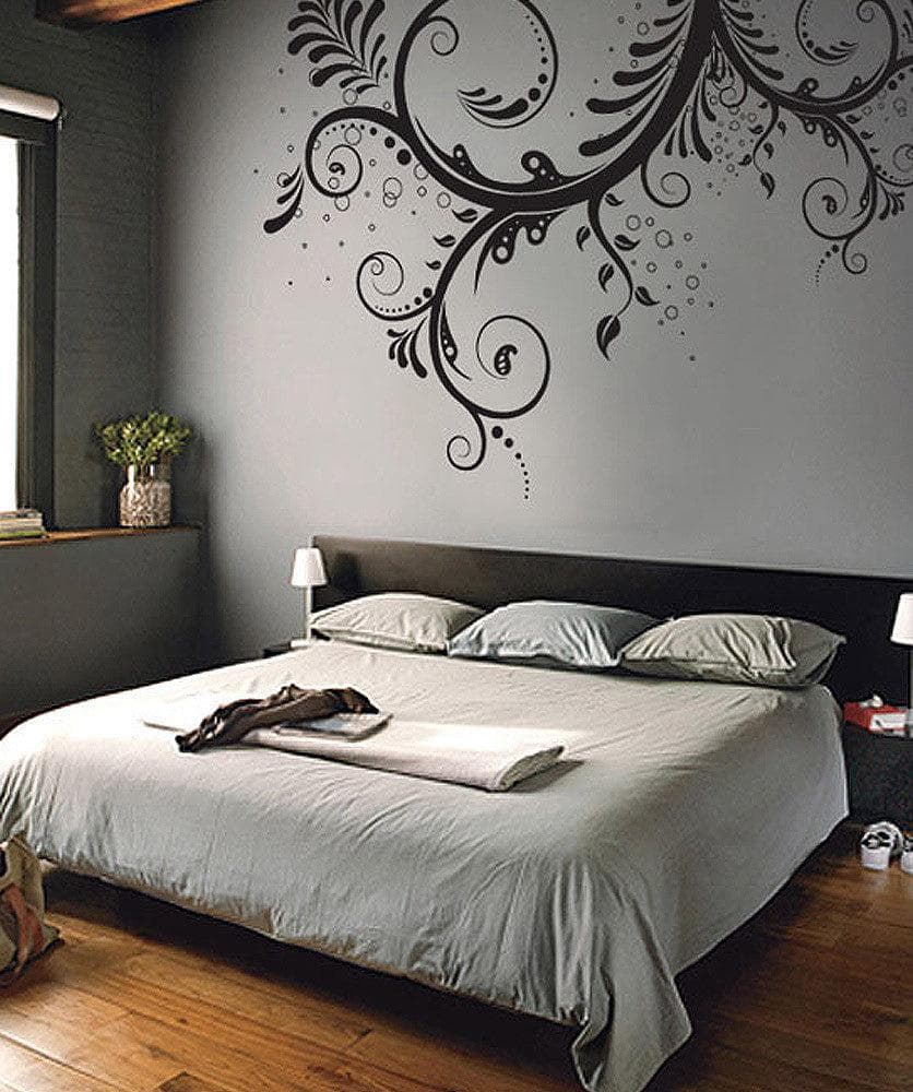A black floral swirl decal on a gray wall in a bedroom. 
