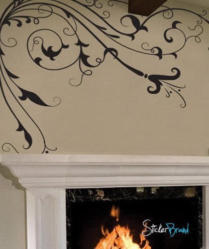 Black floral vines with leaves on a white wall above a fireplace.