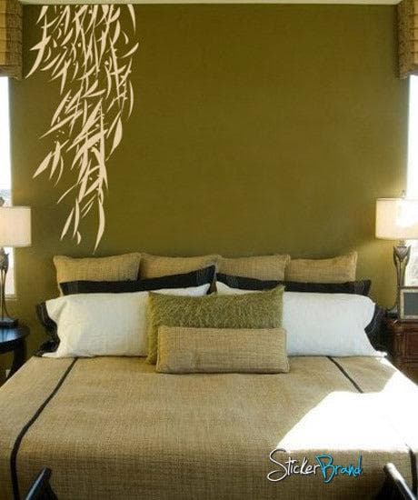 Vinyl Wall Decal Sticker Hanging Bamboo Leaves on a green wall above a bed with pillows.