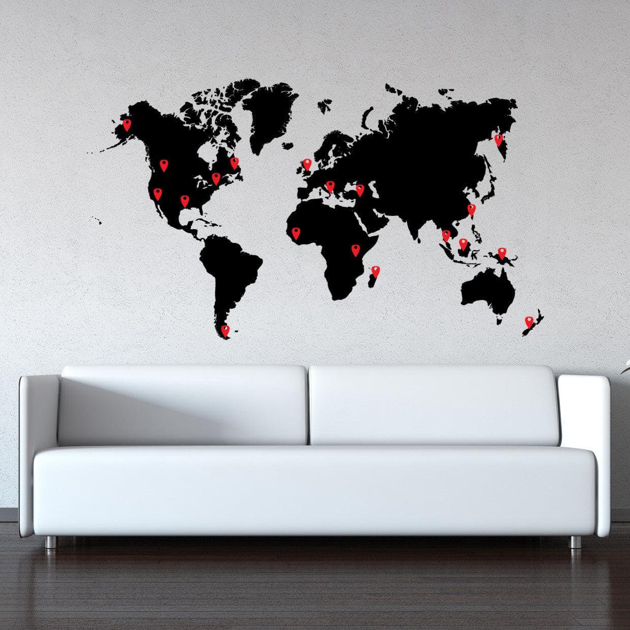 A black world map wall decal on a white wall.