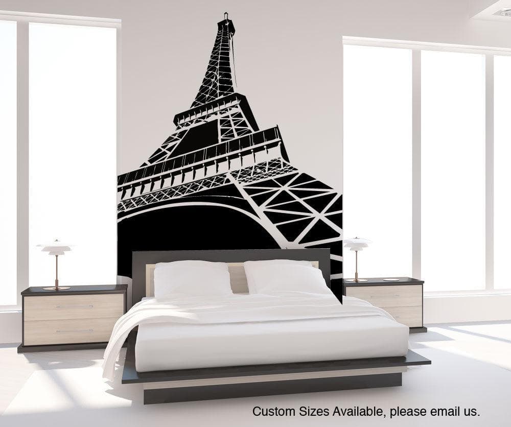 A black decal of the Eiffel Tower on a white wall in a bedroom.