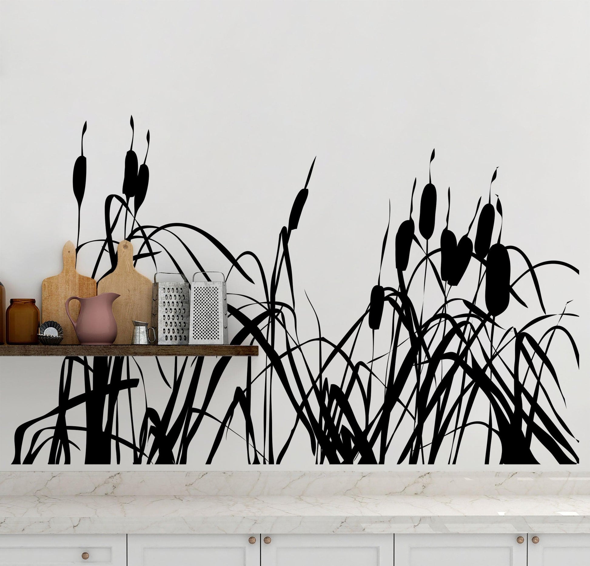 A black cattails decal on a white wall near a wooden shelf and white marble counter.